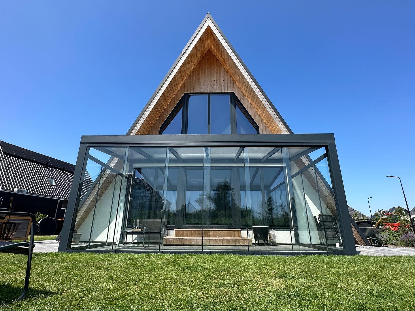 Glazen veranda aan A-frame woning